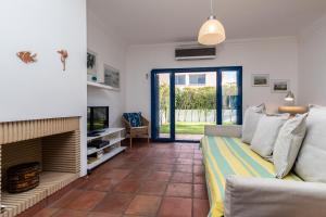 un soggiorno con divano e camino di Villa Blue Garden by ALGARVEMANTA a Manta Rota