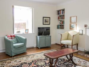 uma sala de estar com duas cadeiras e uma televisão em St Agnes em Duns