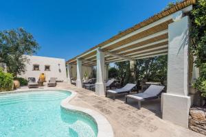 a swimming pool with chairs and a pergola at Bilocale 103-tia Maria Country Inn in Racale