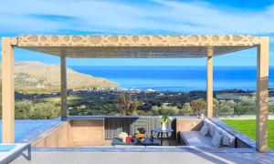 a pergola on a patio with a view of the ocean at Mistral Suite Heated Pool in Georgioupoli