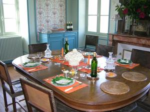 een eetkamer met een tafel met wijnflessen bij Château des Lutz in Daon