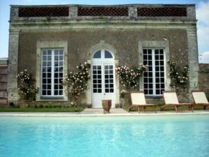 ein Haus mit zwei Stühlen und einem Pool in der Unterkunft Château des Lutz in Daon