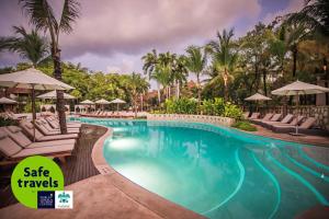 a pool at a resort with chairs and umbrellas at Mahekal Beach Front Resort & Spa in Playa del Carmen