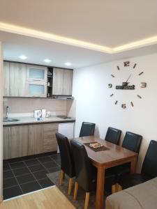 een keuken met een tafel en een klok aan de muur bij Apartments NS Novaković in Zlatibor