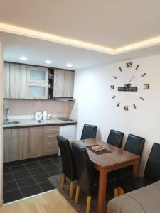 a kitchen with a table and a clock on the wall at Apartments NS Novaković in Zlatibor +23 photos