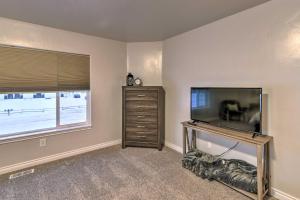 a living room with a flat screen tv and a dresser at Cozy Anchorage Townhome Less Than Half Mile to Jewel Lake! in Anchorage