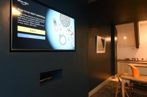 a flat screen tv hanging on a wall in a kitchen at Slps 14 Hot Tub, Bar & Outdoor Terrace in Manchester