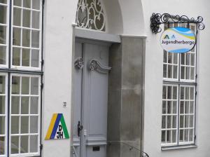 a sign on the side of a white building with a door at Jugendherberge Lübeck Altstadt in Lübeck