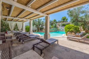 an outdoor patio with lounge chairs and a swimming pool at Monolocale105-tia Maria Country Inn in Racale