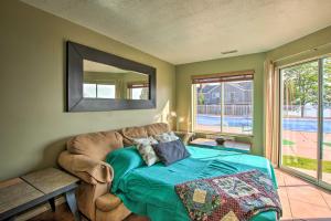 a bedroom with a bed and a couch and a mirror at Garden City Condo with Pool Access by Bear Lake! in Garden City