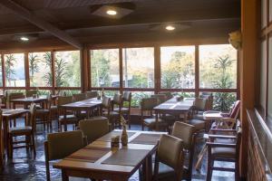 a dining room with tables and chairs and windows at Hotel Portal das Aguas in Águas de São Pedro