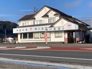 un edificio con escritura al lado de una calle en Kamogawa Shokudo - Vacation STAY 15119v, en Kamogawa