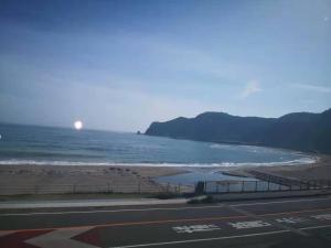 una vista de la playa con el sol a lo lejos en Kamogawa Shokudo - Vacation STAY 15119v, en Kamogawa
