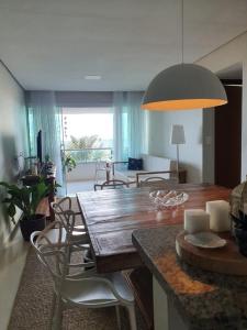 a living room with a wooden table and chairs at Assossego - Seu sossego a 200m do mar! in Ilhéus