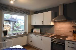 a kitchen with white cabinets and a sink and a window at Sylvia Helene Lafrenz in Winkl bei Grabenstätt