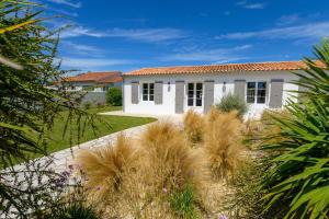 a white house with a garden in front of it at La Cabane du pêcheur in La Couarde-sur-Mer