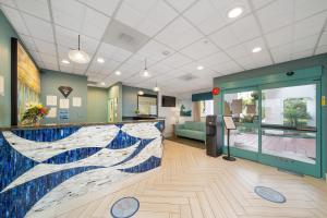 a lobby with a counter with a painting of a wave at Casablanca Inn in San Clemente +59 photos