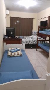 Pokój z 2 łóżkami, biurkiem i komputerem w obiekcie Suites Vista Do Parque w mieście Penha