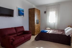 a living room with a couch and a bed at Calasole Country House in Torre Lapillo
