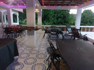 a patio with chairs and tables and a table and lights at Polish Princess Guest House in Port Antonio