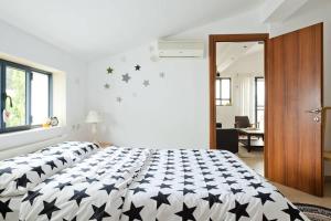 Un dormitorio con una cama con estrellas negras. en Judith's Place - Stylish Apartments en Ramat Gan