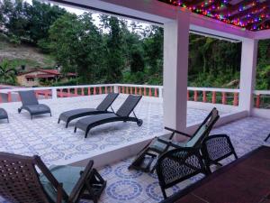 a porch with chairs and a table and lights at Polish Princess Guest House in Port Antonio