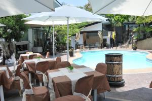 a restaurant with tables and umbrellas next to a pool at Date & Dine Resort in Antipolo