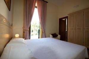 a bedroom with a large white bed and a window at Divina House B&B in Sorrento