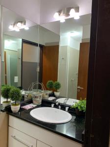 a bathroom with a sink and a large mirror at Novum Suites in Cordoba