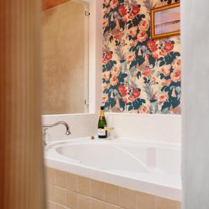 a bathroom with a bath tub with a floral shower curtain at Palihouse Santa Barbara in Santa Barbara