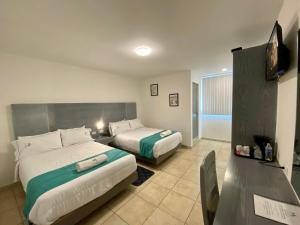ein Hotelzimmer mit zwei Betten und einem Fernseher in der Unterkunft Hotel Maria Sofia ViaCapu in San Felipe Hueyotlipan
