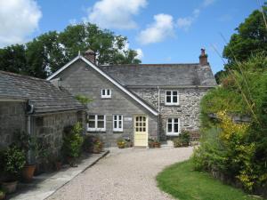 an old stone house with a yellow door at Little Pengelly Farm in Crowan