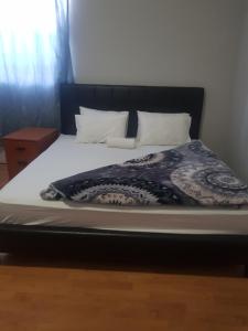 a bed with a black headboard and white sheets and pillows at SALAMA LODGE in Cape Town +5 photos
