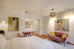 Boutique Apartments Freiburg - Eva في فريبورغ ام بريسغاو: غرفة نوم بها سرير وأريكة وطاولة