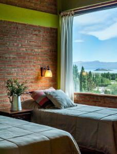 a bedroom with two beds and a large window at Posada Larsen in El Calafate