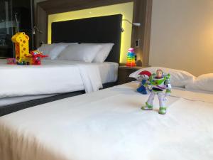 a hotel room with two beds with toy figurines on them at Novotel São Paulo Berrini in São Paulo