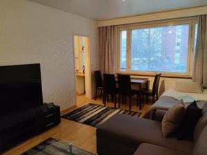een woonkamer met een bank, een tv en een tafel bij M Apartments Jurvalankatu in Tampere