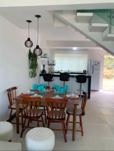 a kitchen and dining room with a wooden table and chairs at MIRANTE ESCARPAS APTO 702 in Capitólio