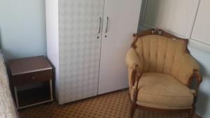 einen Stuhl in einem Zimmer mit einem Kühlschrank und einem Tisch in der Unterkunft Esin Pansiyon in Tokat