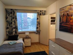 een kleine slaapkamer met een bed en een raam bij M Apartments Jurvalankatu in Tampere