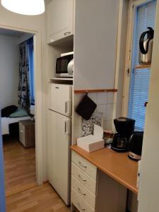 een kleine keuken met een aanrecht en een koelkast bij M Apartments Jurvalankatu in Tampere