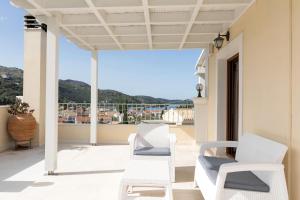 een balkon met witte stoelen en uitzicht op de oceaan bij Kassiopi View Villas-Corfu-Villa Eleni,4 bedrooms,large private pool,prime location in Kassiopi