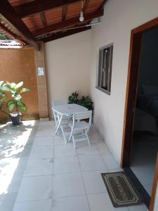 eine Terrasse mit einem weißen Tisch und einem Tisch in der Unterkunft Suites do Ratinho in Pirenópolis