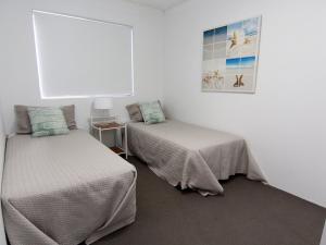 a room with two beds and a picture on the wall at The Breakers 8 in Forster