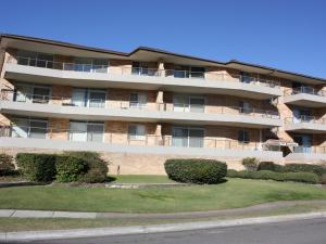 a large brick building with bushes in front of it at The Breakers 10 in Forster