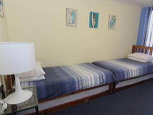 a bedroom with two twin beds and a lamp and a lamp at The Breakers 10 in Forster