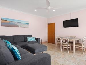 a living room with a couch and a table at Debra Court 11 in Forster