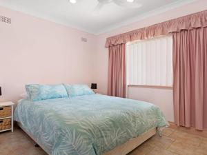 a bedroom with a bed and a window at Debra Court 11 in Forster