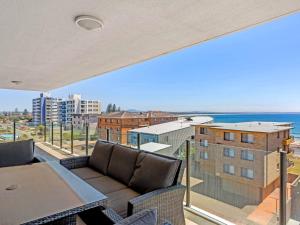 einen Balkon mit einem Sofa und Meerblick in der Unterkunft Strand Beachside 503 in Forster