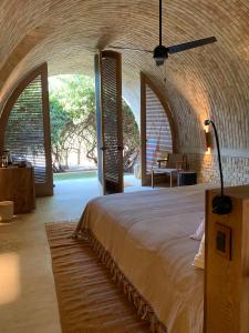 プエルト・エスコンディードにあるCasona Sforzaのアーチのあるベッドルームで、大型ベッド1台が備わります。